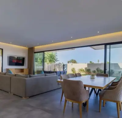 a living room with a couch and a table and chairs at Villa Prestige in Bir Jedíd Saint-Hubert