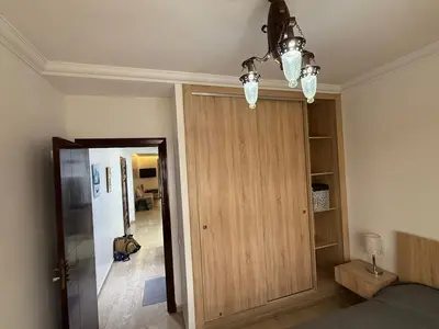 a bedroom with a wooden door and a chandelier at Modern appt with pool and easy access to beach in Skhirat