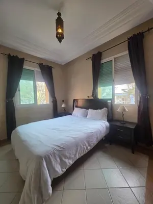 a bedroom with a large bed and two windows at Dar Tourabi in Casablanca