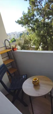 a table and chairs on a balcony with a window at Chic studio! Comfort and perfect location! in Rabat