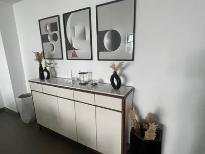a white cabinet with three pictures on the wall at Nams Casa Home in Casablanca