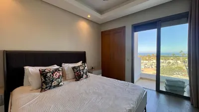 a bedroom with a bed with a view of the ocean at Family Trips or Professional Travels -By AppartAli in Casablanca