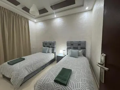 two beds sitting next to each other in a room at Appatement authentique 7mn Hay Riad in Temara