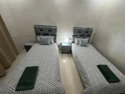 two beds sitting next to each other in a room at Appatement authentique 7mn Hay Riad in Temara