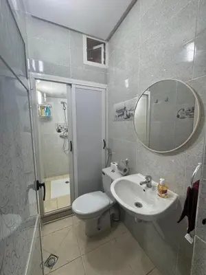 a bathroom with a toilet and a sink and a mirror at Appatement authentique 7mn Hay Riad in Temara