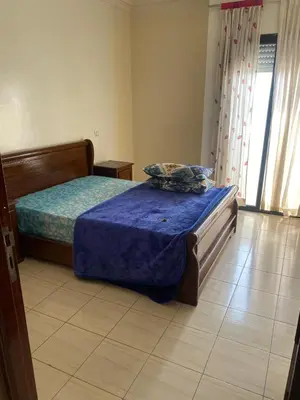 a bedroom with a bed with a blue comforter at Saad home in Casablanca
