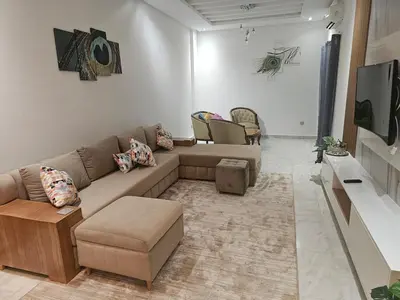 a living room with a couch and a tv at Sables d'or flat apartement in El Harhoura