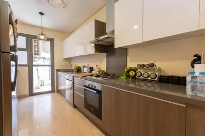 a kitchen with a stove top oven next to a refrigerator at Homerest appartement Casablanca in Casablanca