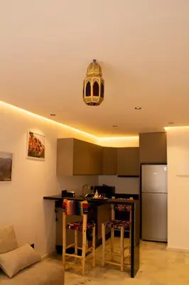 a kitchen with a table and a refrigerator at Terrace Solarium & Fitness & Berber Tradition in Casablanca
