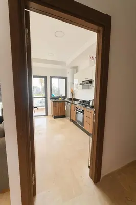 a kitchen with a door open to a living room at Jolie appartement bord de mer de standing in Mohammedia