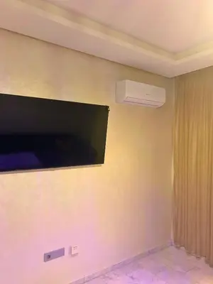 a room with a wall with a tv and a fan at Charming Apartment Residence Ocean Park Pool, Sea in Aïn Harrouda