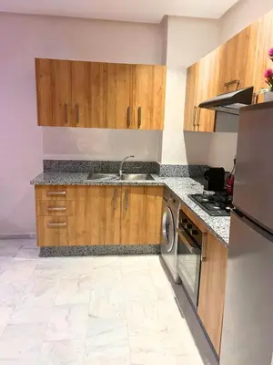 a kitchen with wooden cabinets and a sink and a dishwasher at Charming Apartment Residence Ocean Park Pool, Sea in Aïn Harrouda