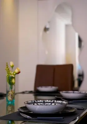 a table with plates and bowls on top of it at Modern Apart Heart of Casablanca Perfect Location in Oulad Akkou