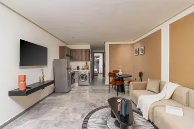 a living room with a couch and a kitchen at The Nest Residence by GoodMove - Gauthier Casablanca in Casablanca