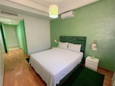 a bedroom with a white bed and a green wall at Casa Stay in Casablanca