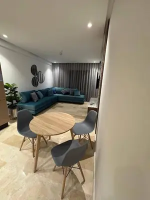 a living room with a blue couch and a table at Studio de lux in Casablanca