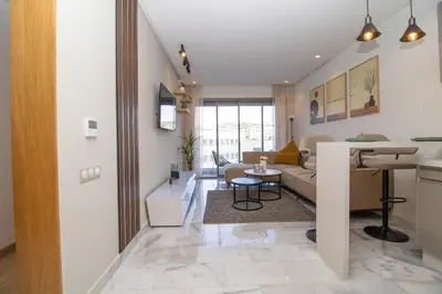 a living room with a couch and a table at Studio Palmier Casablanca in Maarif