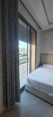 a bedroom with a bed and a large window at appartement a louer sable d'or mansouria in Pont Blondin