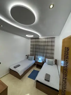 a room with two beds and a mirror on the ceiling at bel appartement in Temara