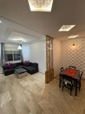 a living room with a couch and a table at bel appartement in Temara