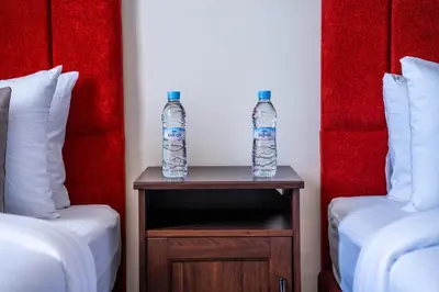 two bottles of water on a table between two beds at Exceptional Penthouse Private Terrace & Pool in Bouznika