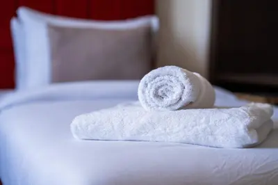 a roll of white towels sitting on top of a bed at Exceptional Penthouse Private Terrace & Pool in Bouznika