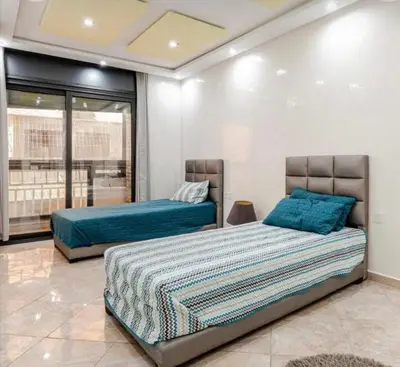 a bedroom with two beds with blue pillows at luxury apartment in casablanca in Maarif