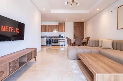 a living room with a couch and a flat screen tv at Cozy Studio with Pool & Parking in Aïn Harrouda