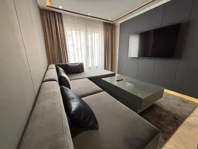 a living room with a couch and a tv at Corniche Casablanca - Kimberly Luxury Suite in Casablanca