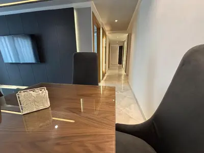 a dining room with a wooden table and chairs at Corniche Casablanca - Kimberly Luxury Suite in Casablanca