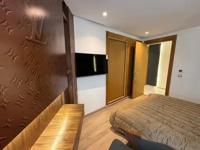 a bedroom with a bed and a tv on a wall at Corniche Casablanca - Kimberly Luxury Suite in Casablanca