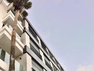 a building with two palm trees in front of it at Calm Studio in Oasis, Near Train Station in Casablanca