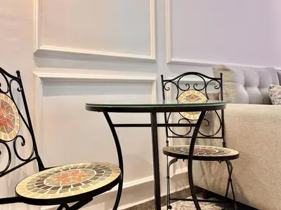 a table and two chairs next to a couch at Cozy, Elegant Apartment, Parking and Fiber in Casablanca