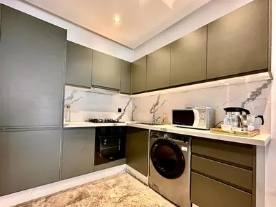 a kitchen with a washing machine and a microwave at Cozy, Elegant Apartment, Parking and Fiber in Casablanca