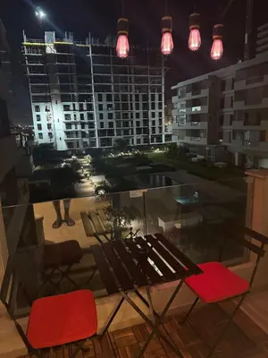 a view of a city at night with chairs and lights at Studio Zenata Central Park Près de la plage Vue Piscine in Aïn Harrouda
