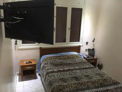 a bedroom with a bed and a dresser and a window at Appartement Familial Emile Zola in Casablanca