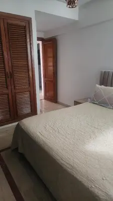 a bedroom with a bed and a wooden door at Studio maarif 75m residense ferme in Casablanca