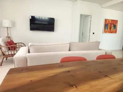 a living room with a white couch and a tv at The Nineteen Racine by IB Signature - Stylish two-Bedroom flat - Wifi, Self Check-in, Day and Night Security, Terrace, free parking, close to all amenities in Casablanca