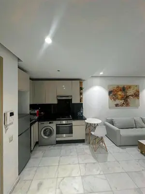 a kitchen with a couch and a stove top oven at Studio de luxe, lumineux et parfait in Casablanca