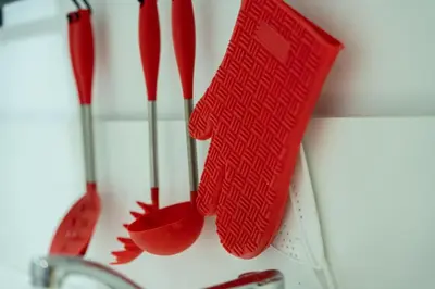 a group of red kitchen utensils hanging from a wall at C07- Pestana - Luxury Hotel Flat - Terrace - Pool in Casablanca