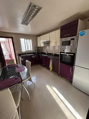 a kitchen with a refrigerator and a table with chairs at Appartement à agdal 2 chambres in Rabat