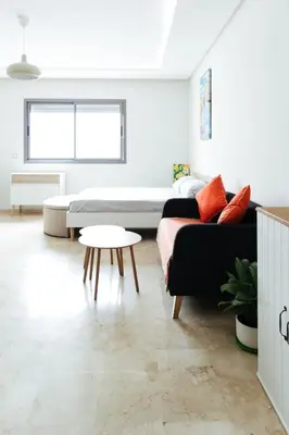 a living room with a couch and a table at Charming Modern Studio near Corniche Mohammedia in Mohammedia