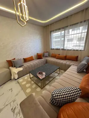 a living room with a couch and a table at Les Flots Blancs - Appartement détente et bonheur côté mer in Bouznika
