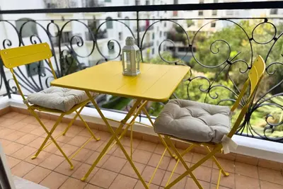 a yellow table and two chairs on a balcony at Elegant & Chic 2 Bedrooms - Maarif in Casablanca