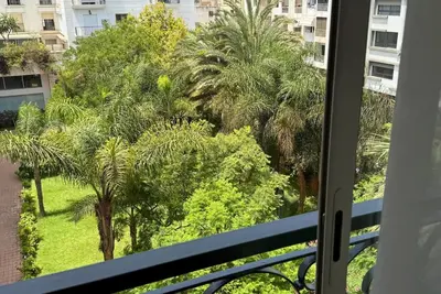 a view of palm trees from a balcony at Elegant & Chic 2 Bedrooms - Maarif in Casablanca