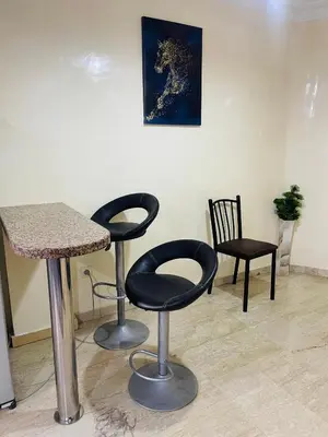 a room with two bar stools and a table and chairs at Résidence Adam in Casablanca