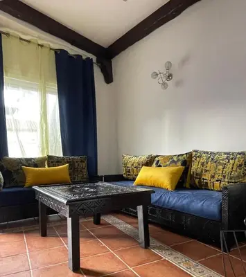 a living room with a blue couch with yellow pillows at Apartment in a waterfront complex in Casablanca