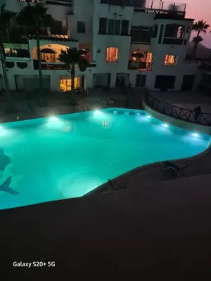 a large swimming pool at night with a building at Apartment in a waterfront complex in Casablanca