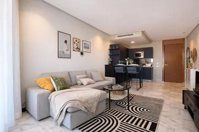 a living room with a couch and a kitchen at Cedar Stays Appartement 1 chambre salon, parking, climatisation, Wifi, balcon in Casablanca