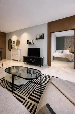 a living room with a glass table and a bed at Cedar Stays Appartement 1 chambre salon, parking, climatisation, Wifi, balcon in Casablanca